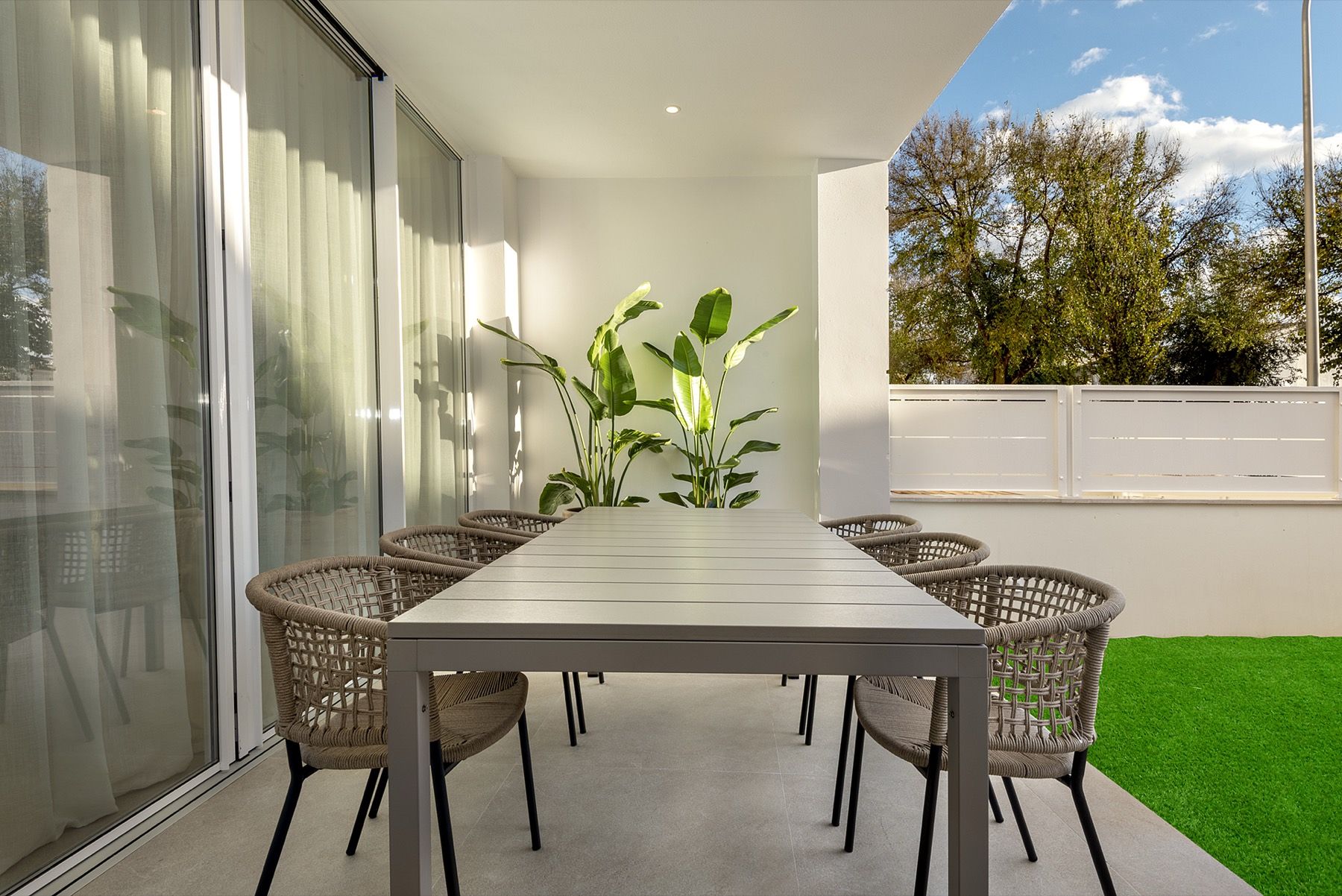 Überdachte Terrasse mit Esstisch und Garten